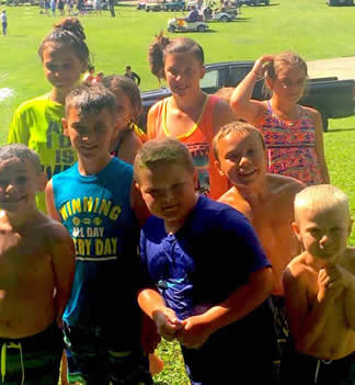 Color photo of 8 kids playing near field. 
